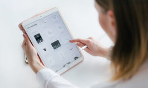 a woman looking at her work on the ipad